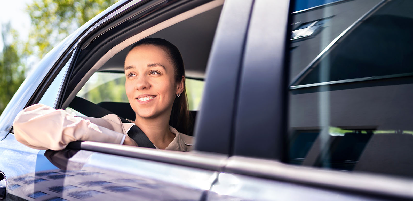 Young woman leaning out of car.