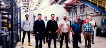 The team behind the assembly of the Grand Tube stands in front of the finished enclosure at beamline 9-ID of the Advanced Photon Source. 