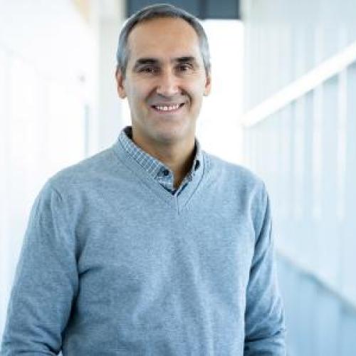 Headshot of a man in a blue shirt.